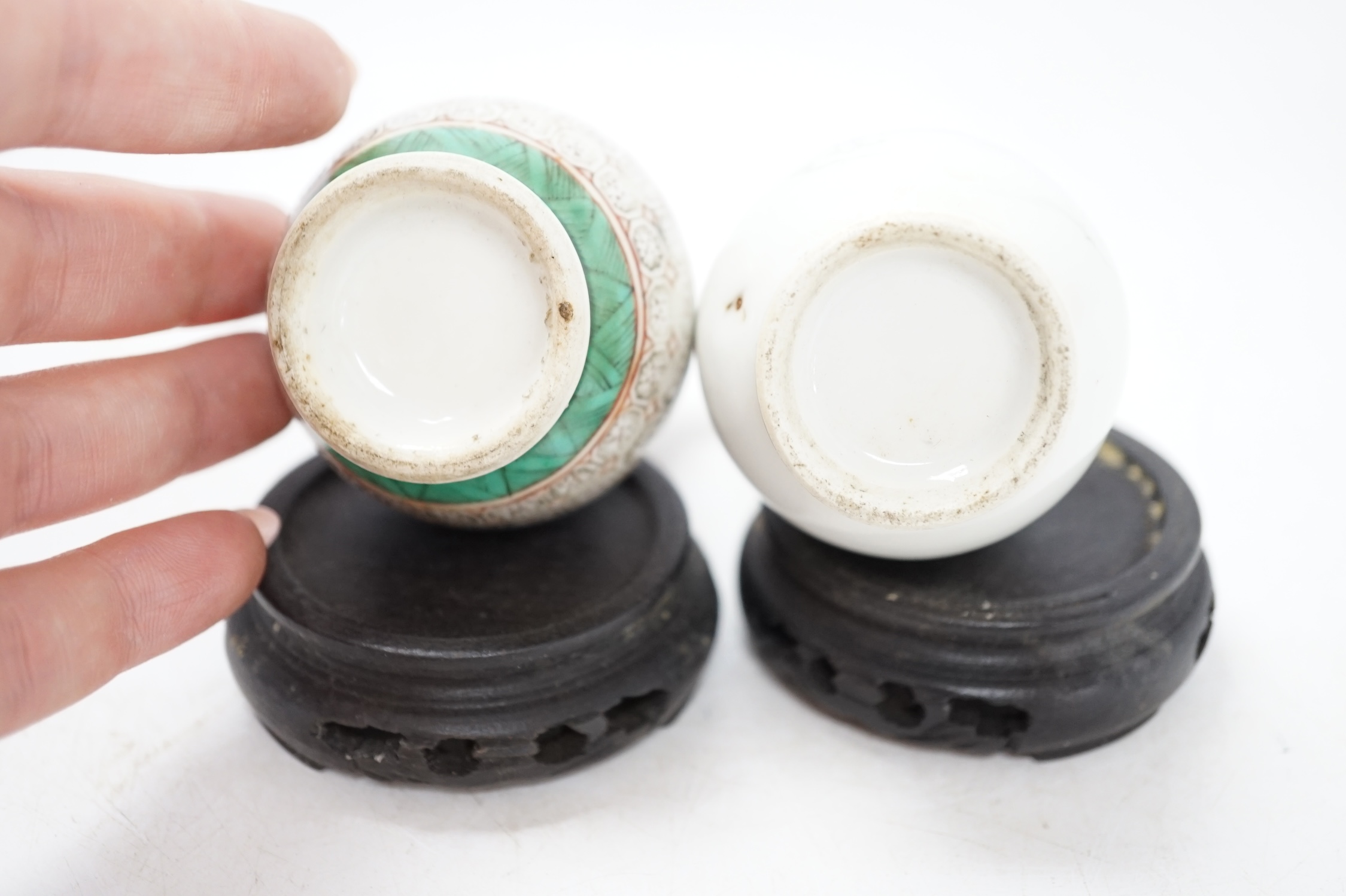 Two miniature Chinese porcelain vases, on hardwood stands, largest 9cm high. Condition - fair